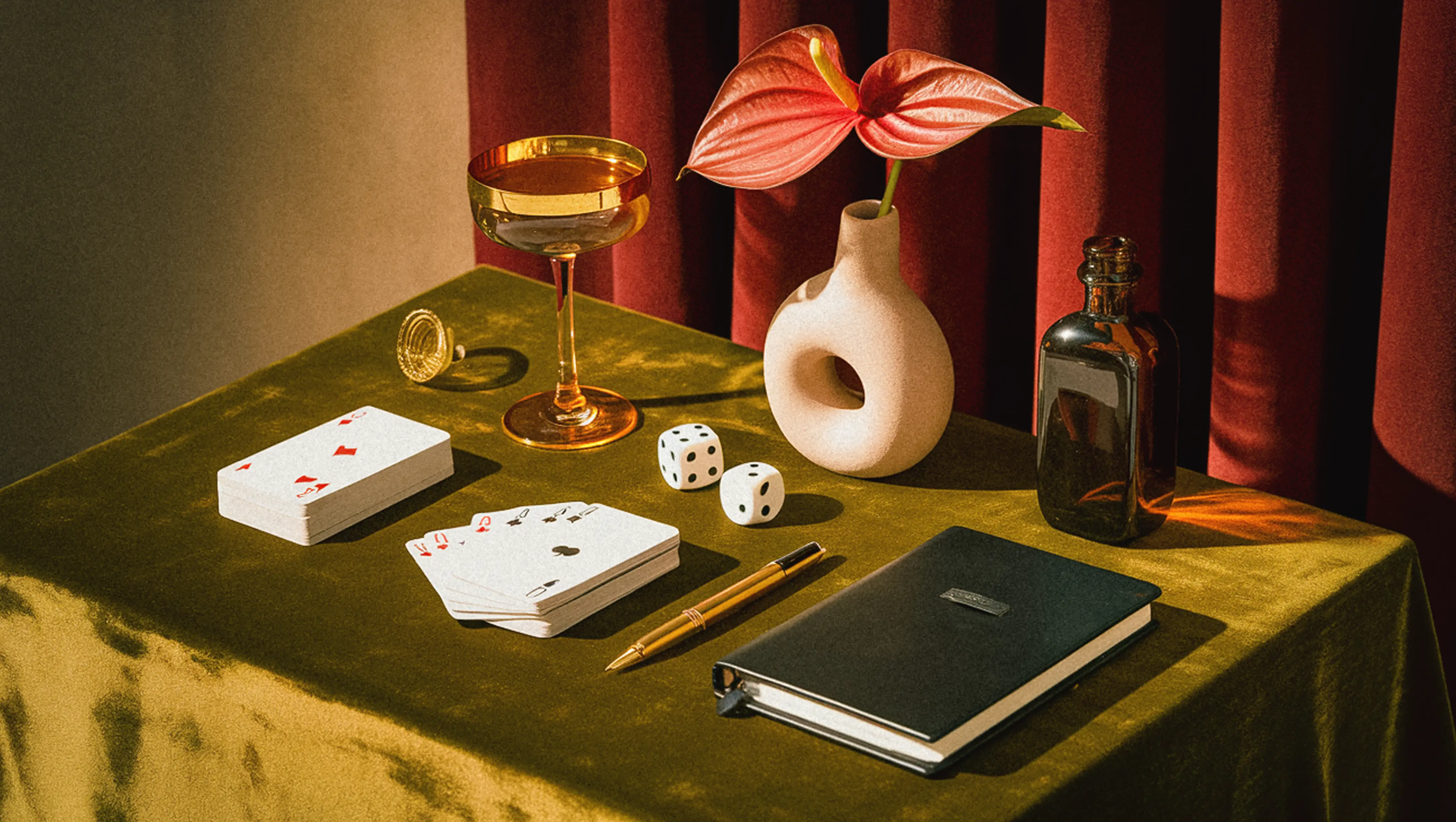 A notebook and cards beside a cocktail on a table